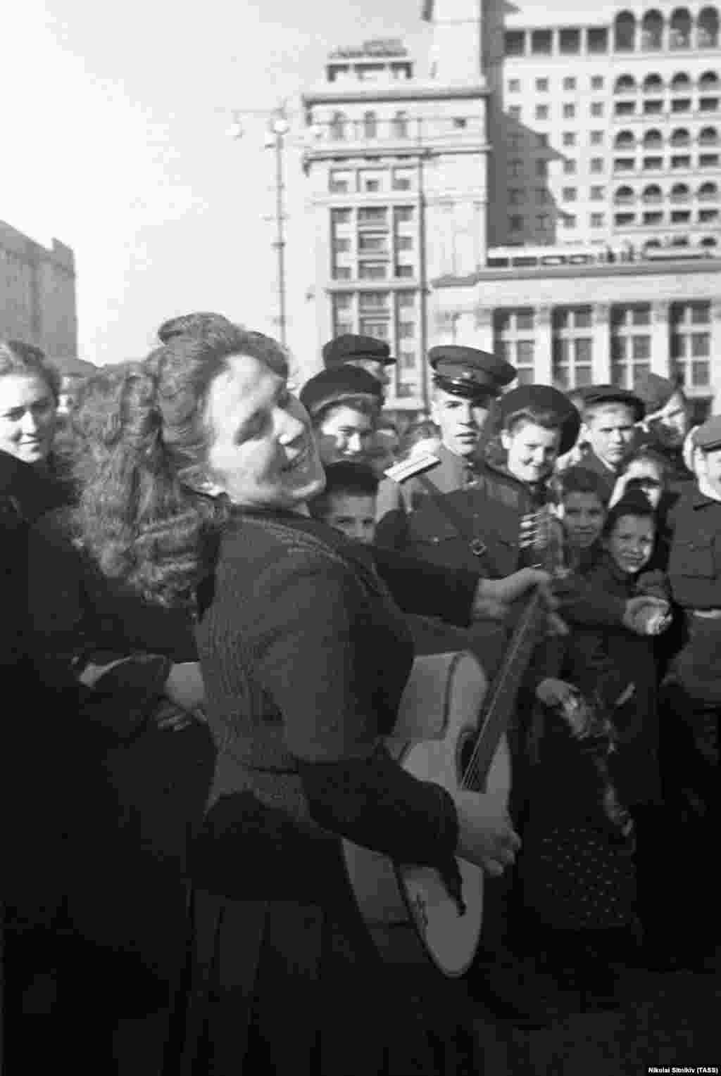 O femeie cântă în centrul Moscovei. În fosta Uniune Sovietică, petrecerea a început pe 9 mai.