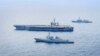 Distrugătorul Seoae Ryu Sung-ryong al marinei sud-coreene, în partea de jos, portavionul Theodore Roosevelt al Marinei SUA, în centru, și distrugătorul Ariake al Forței Maritime de Autoapărare a Japoniei, sus, în timpul unui exercițiu naval comun din 11 aprilie 2024.