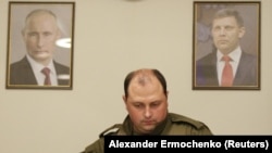 З 2014 року Дмитро Трапезников обіймав керівні посади в угрупованні «ДНР», а після вбивства голови бойовиків Олександра Захарченка був короткий час в.о ватажка «ДНР». На фото Трапезников між портретами Володимира Путіна і Олександра Захарченка. Донецьк, 31 серпня 2018 року