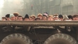 Grup de tineri revoluționari români în spatele unui vehicul al Armatei.