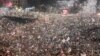 Studenții și manifestanții antiguvernamentali își aprind telefoanele mobile în timpul unui protest la Belgrad pe 15 martie.