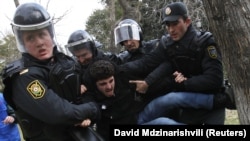 Police detain a man who was protesting in solidarity with Ismayilli residents after a riot in Baku on January 26.