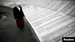 Mejra Dzogaz caută numele rudelor ucise în timpul genocidului de la Srebenica.
