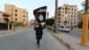 Un membru al militanților Statului Islamic flutură un steag în orașul sirian Raqqa.