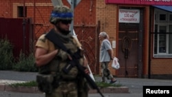 A Ukrainian serviceman patrols in the Russian town of Sudzha, which Kyiv seized control of this month.