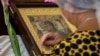 Женщина молится у иконы Пресвятой Богородицы в храме Иоанна Предтечи в городе Керчи. 