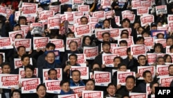 Poslanici i članovi glavne opozicione Demokratske partije drže plakate na kojima piše "Jun Suk Jeol treba da podnese ostavku" na mitingu protiv južnokorejskog predsednika u Nacionalnoj skupštini u Seulu, 4. decembra 2024.