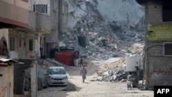 Copii palestinieni printre ruinele unui cartier rezidențial din sudul orașului Khan Yunis din Fâșia Gaza, la 5 iulie 2024.