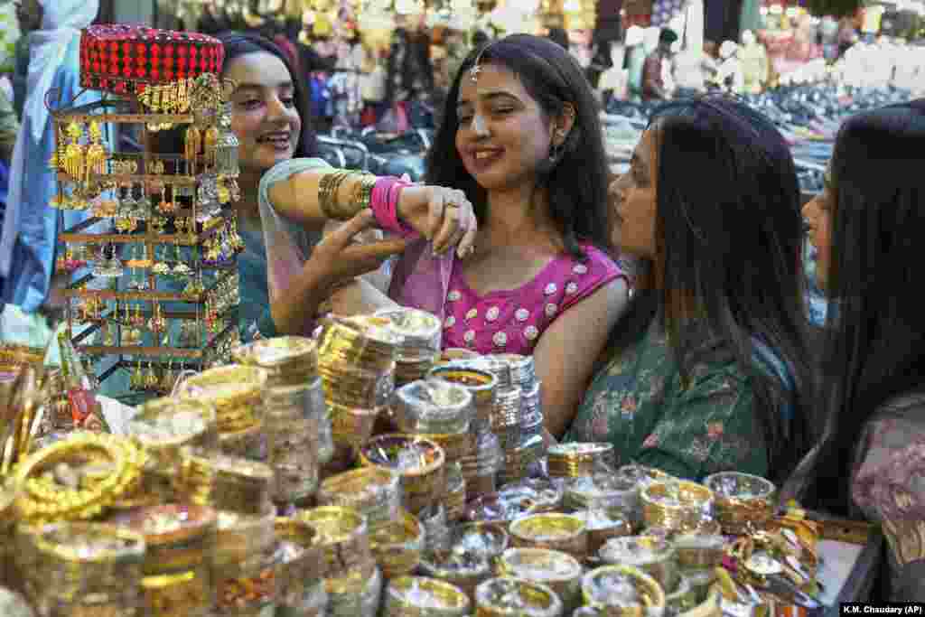 Girls in Lahore look at traditional bangles and costume jewelry as they visit a market to shop for the upcoming Eid al-Fitr celebrations in Pakistan.