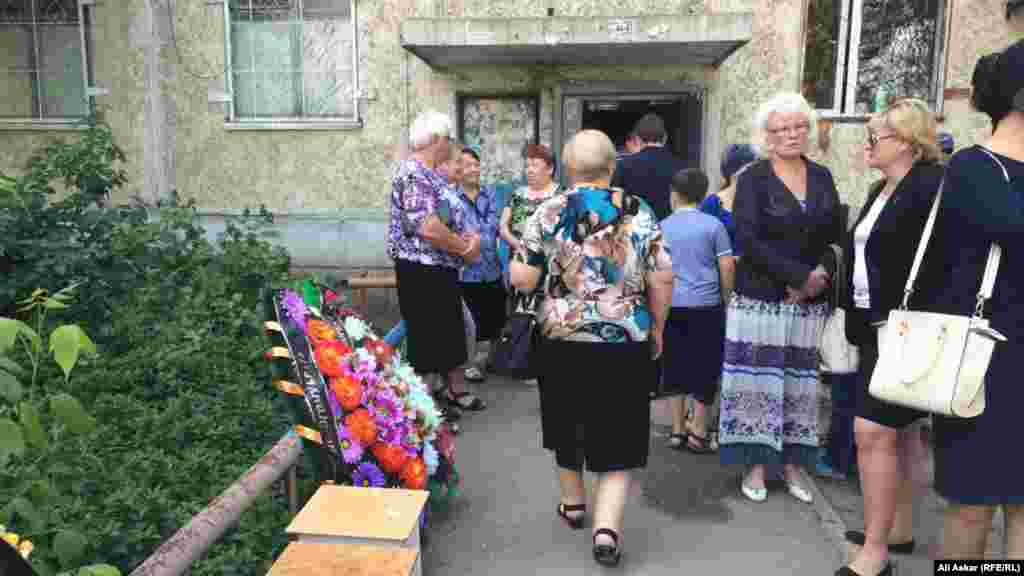 Прощание с еще одним погибшим в ходе теракта, 68-летним Николаем Онищенко, началось в 10 часов утра возле дома №12 по улице Алии Молдагуловой. Магазин «Паллада» находится на первом этаже здания.