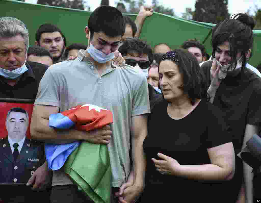 The son and widow of Azerbaijani Colonel Ilgar Mirzayev attend his funeral in Baku. Mirzayev was among five Azerbaijani soldiers killed in cross-border clashes on July 14.