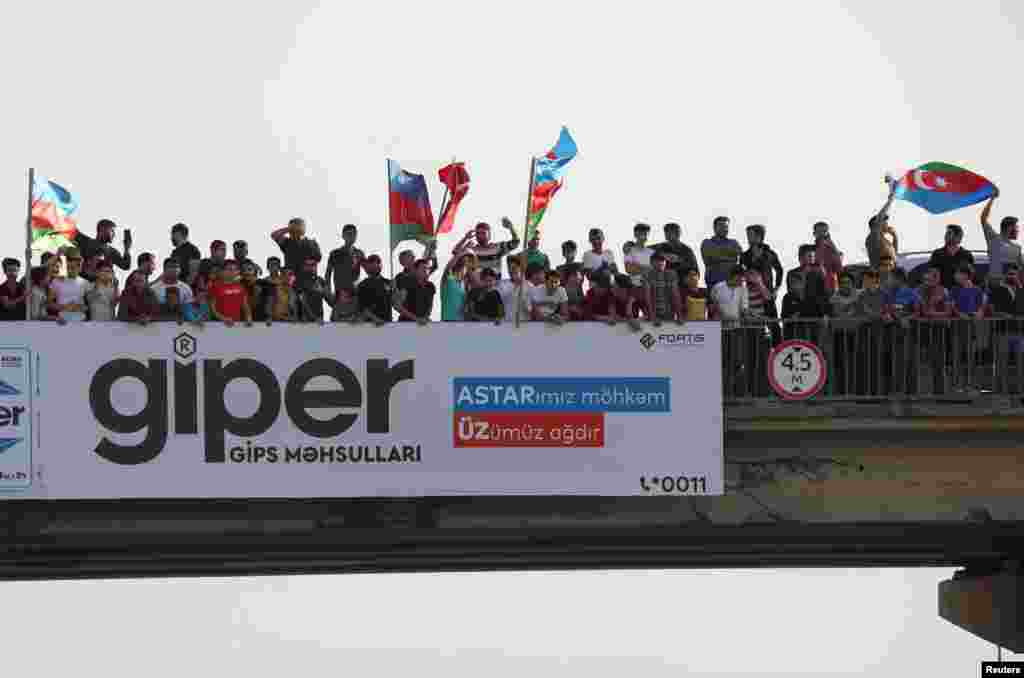 People gather on an overpass to cheer Azerbaijani soldiers in Baku shortly after the breakout of the current conflict in Nagorno-Karabakh on September 27. 
