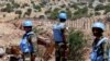 Soldiers from the United Nations Interim Forces in Lebanon (UNIFIL) stand along the barbed-wire fence marking the border with Israel. 