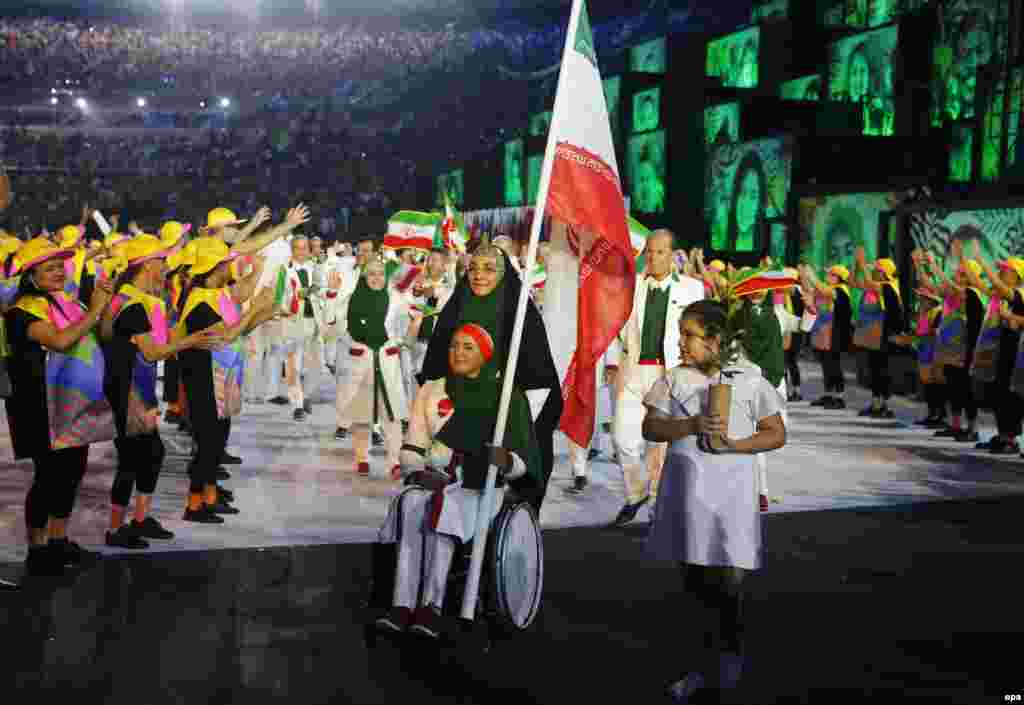 Zahra Nemati (center) of Iran leads her team into the stadium. Nemati, an archer, became Iran's first-ever female flag bearer. She will compete for Iran in both the Olympic and the Paralympic games next month.