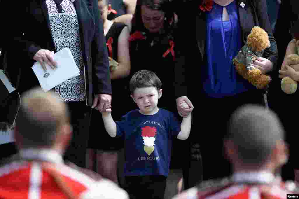 Jack Rigby watches as the coffin of his father, Fusilier Lee Rigby, is carried by members of his regiment after his funeral service at the parish church in Bury, northern England, on July 12. The soldier was murdered in London in broad daylight by Islamist extremists on May 22. 