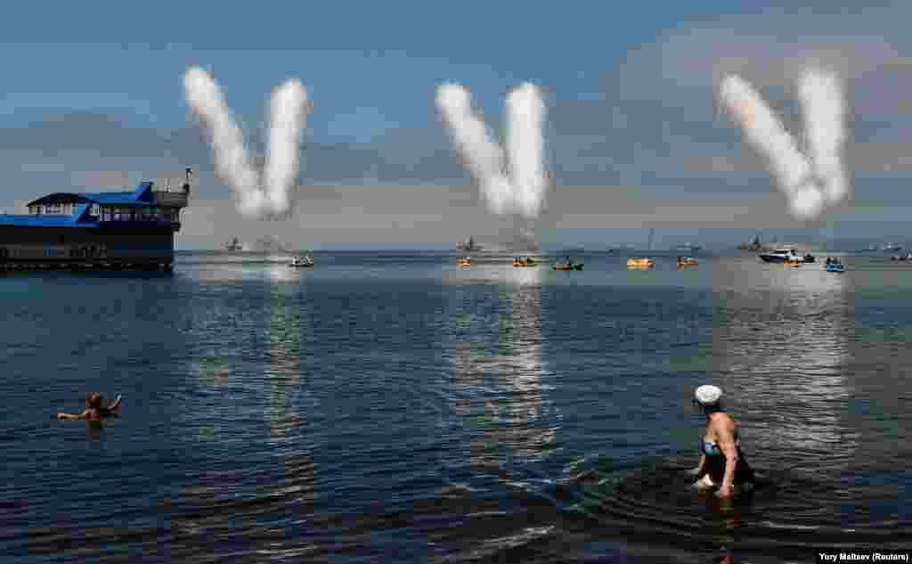 Россия. Люди наблюдают за празднованием российского Дня Военно-морского флота во Владивостоке 29 июля. (Reuters/Yuti Maltsev)