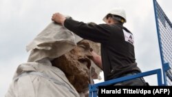 A worker helps install a statue of German philosopher, economist, political theorist and sociologist Karl Marx in his hometown of Trier last month.