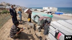 Palestinieni strămutați, lângă corturile din tabăra Deir al-Balah, în centrul Fâșiei Gaza. 3 iunie 2024