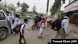په کراچۍ کې د یوه ښوونځي زده کوونکو تمبوزکونه وهلي او سکول ته روان دي - د ۲۰۲۰ز کال د نومبر میاشتې انځور. 