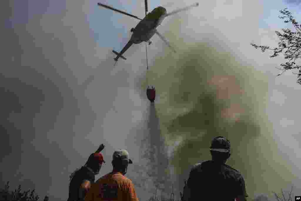 Helikopter izliva vodu iznad požarnom razornog sela Sirtkoi, u blizini Manavgata, Antalija, Turska, nedelja, 1. avgusta 2021.