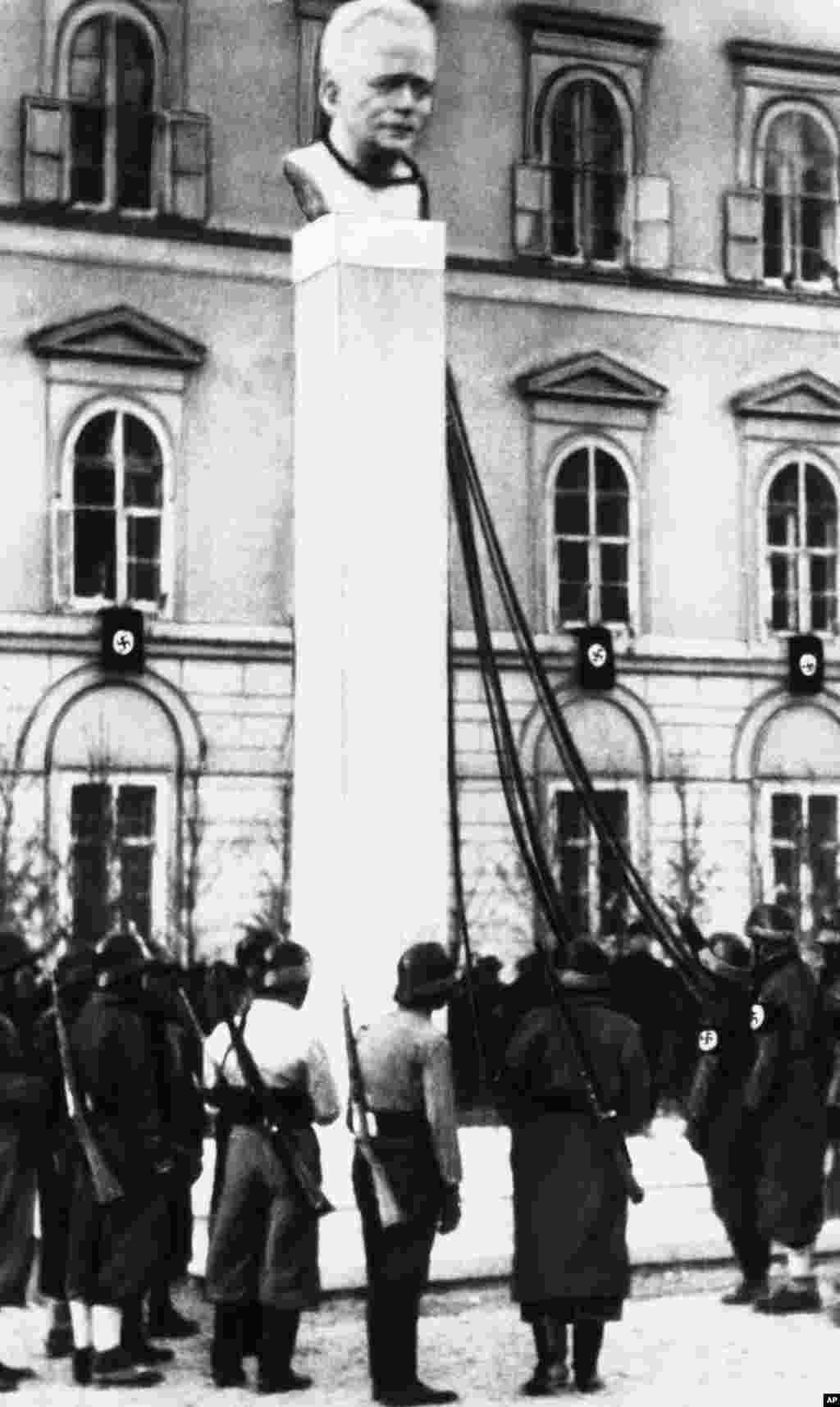 Nacističke trupe čekaju naredbu da sruše poprsje austrijskog kancelara Engelberta Dollfussa nakon aneksije Austrije od strane nacističke Njemačke 1938. godine.