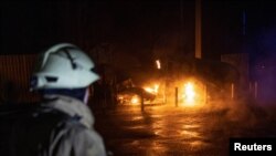 Spasilac posmatra mjesto ruskog raketnog udara u selu Kotljari kod Harkiva 22. aprila.