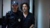 Laurent Vinatier (right) is escorted into a courtroom in Moscow on June 7.