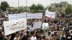 Antiregime protesters carry banners during a rally in Talbiseh, in the central Syrian province of Homs, last month.