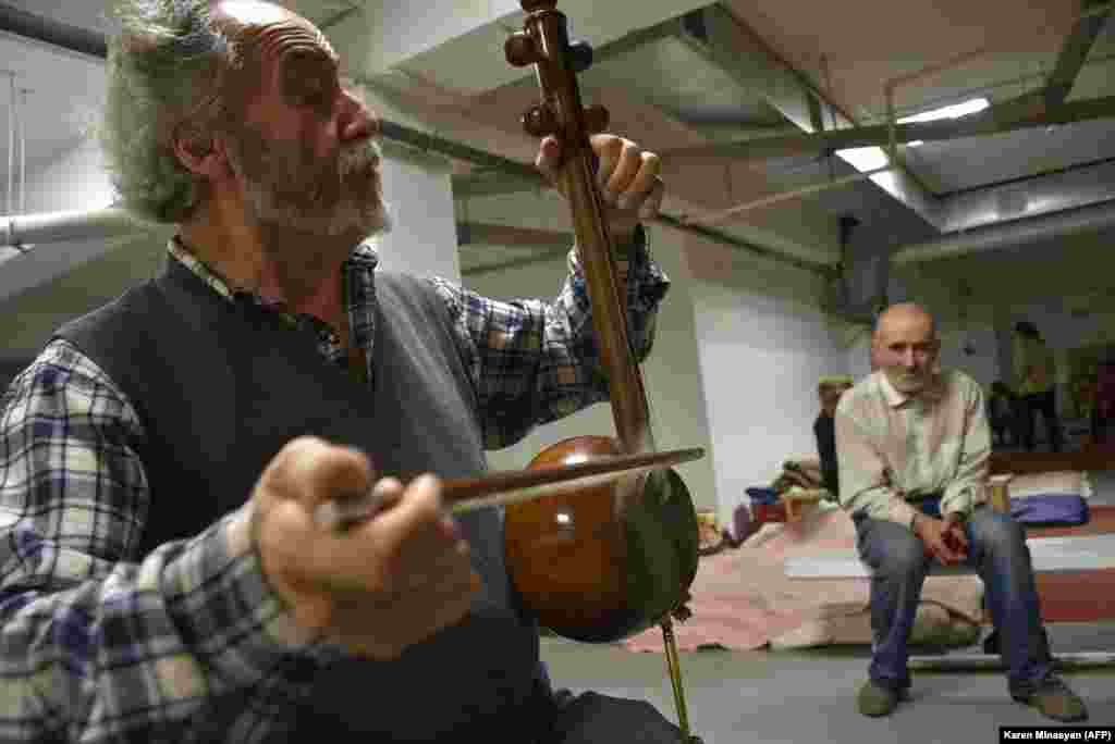 Armenian musician Hakob Khalatian plays his kamancha string instrument in a bomb shelter in Stepanakert on November 5. 