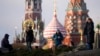 Люди гуляют в парке «Зарядье» на фоне Спасской башни Кремля и собора Василия Блаженного в Москве, 31 января 2025 года
