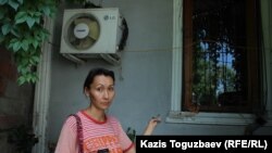 Гражданская активистка Жазира Тоганбаева показывает место, откуда сотрудники КЧС производили вскрытие окна, чтобы проникнуть в дом Рамазана Есергепова. Алматы, 2 августа 2017 года.
