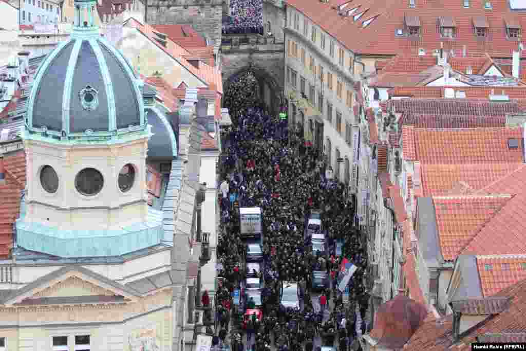 The procession stretches all the way across the Charles Bridge as mourners follow the hearse carrying the late Czech leader to Prague Castle, where he will lie in state until his funeral on December 23.