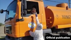 Коронавирусни аниқлаш учун ишини давом эттираётган ҳайдовчилар тана ҳарорати ўлчанмоқда, апрель, 2020