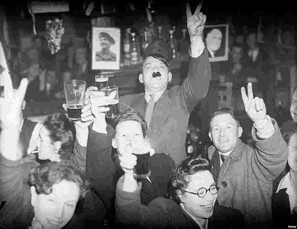Londonezi care beau bere într-un pub din Lambeth. Printre ei, este și un bărbat care și-a umplut nările cu păr, o parodie a celebrei mustăți a lui Hitler.