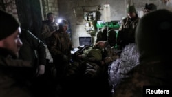 Medicii și membrii Brigăzii 24 din Ucraina tratează un soldat rănit lângă Bakhmut, în regiunea Donețk, pe 1 decembrie.