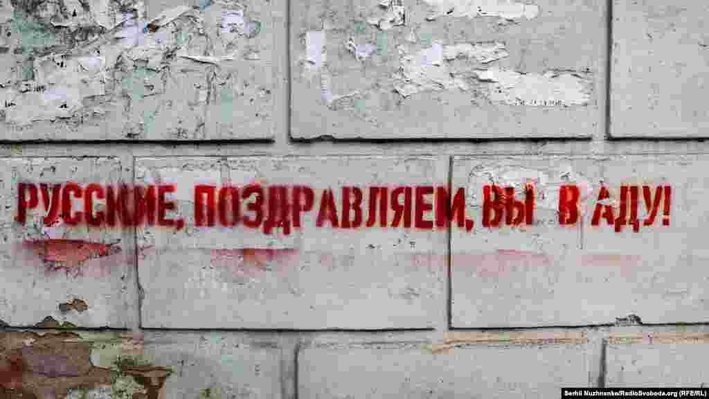Такі графіті з написом російською мовою «Русские, поздравляем, вы в аду!» з’явилися на вулицях одного з населених пунктів на Донеччині, що неподалік від лінії фронту. Його контролюють військові ЗСУ, 29 апреля 2022 года
