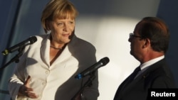 German Chancellor Angela Merkel (left) and France's President Francois Hollande address the media before talks at the Chancellery in Berlin on August 23.