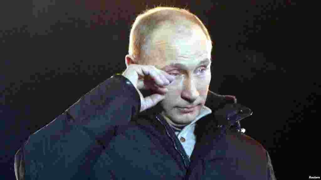 Premierul Vladimir Putin pare să șteargă o lacrimă în timp ce se adresează susținătorilor în timpul unui miting în Piața Manezh, lângă Kremlin, în martie 2012.