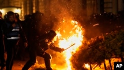 Policija pokušava ugasiti požar dok su pristalice Calina Georgescua protestirale nakon što je rumunska izborna komisija odbila njegovu kandidaturu na ponovljenim predsjedničkim izborima u Bukureštu, Rumunija, u nedjelju, 9. marta 2025.