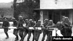 Тарыхый сүрөт: немец аскерлери 1939-жылдын 1-сентябрында Польшанын түндүгүндөгү Сопот шаарындагы чек ара тосмосун талкалап жаткан учур 