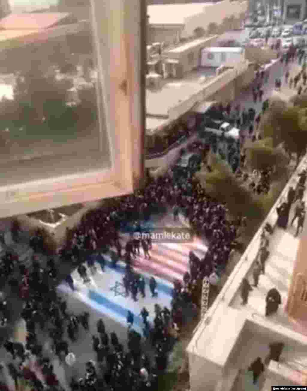 Demonstranti izbjegavaju da stanu na američku i izraelsku zastavu tokom okupljanja u kampusu&nbsp; Behesthi univerziteta, 12. januara. Samo devet dana ranije, druge skupine ljudi su viđene kako pale te iste zastave nakon što je u američkom napadu dronom ubijen iranski vojni zapovjednik Qasem Soleimani.&nbsp;