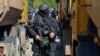 Kosovski policajac stoji blizu kamiona koje su lokalni Srbi postavili da blokiraju cestu u Jarinju na sjeveru Kosova (28. rujna 2021.)