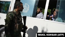 An Afghan National Army soldier talks with Taliban prisoners as they sit inside a vehicle during their release from the prison next to the U.S. military base in Bagram, north of Kabul, on May 26.