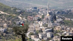 Palestinska zastava na drvetu tokom protesta protiv jevrejskih naselja u selu An-Naqura blizu Nablusa, na izraelskoj okupiranoj Zapadnoj obali 29. marta 2021. 