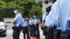 Policija ispred Višeg suda u Hong Kongu, gdje su se okupile i pristalice osuđenog Tong Jing Kita, 30. jul 2021. 