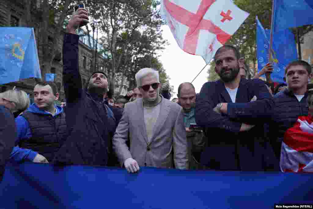 Fiul lui Bidzina Ivanishvili, Tsotne Ivanishvili (centru) și sportivul și candidatul adjunct Geno Petriașvili (al doilea la dreapta) se alătură procesiunii susținătorilor Visului Georgiei înainte de începerea mitingului preelectoral.