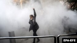 A young woman raises her fist aloft as Iranian students clash with riot police in Tehran during antigovernment protests that rocked Iran for around two weeks at the turn of the year.