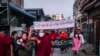 Aktivisti i budistički sveštenik učestvuju na protestu protiv vojne hunte, u gradu Mandalaju, na Mjanmaru. Na plakatu piše - "Ko sme da bude sa druge strane narodne volje". Madalaj, Mjanmar, 1. februar 2022. godine. 