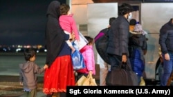 Grupa Avganistanaca sa decom po dolasku u Prištinu, nakon čega su odvezeni u kamp Liya, oktobar 2021.