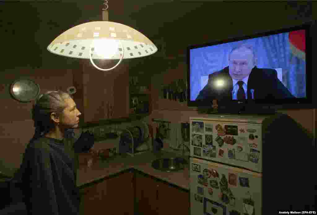 Орусиянын президенти Владимир Путин 21-февралда Коопсуздук кеңештин жыйынында Москва Украинанын чыгышындагы эки аймактын эгемендигин тааный турганын айтты. Сүрөттө жай тургун орус президентинин айткандарына кулак салууда. 